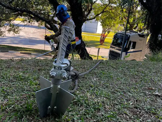 ProLLude cravado no talude gramado, com técnico de capacete e caminhão ao fundo