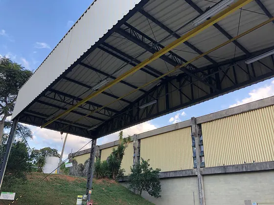 Trilho rígido amarelo sob a cobertura metálica de uma baia de carregamento