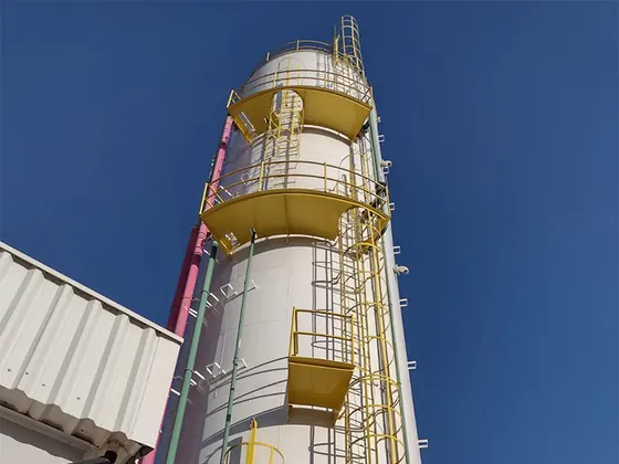 Silo com escadas marinheiro amarelas com gaiola e plataformas contra o céu