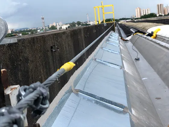 Linha de vida acompanhando a calha e a platibanda de concreto