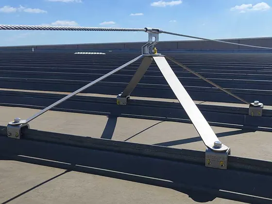 Interface zipada inox com braços sobre telhado metálico escuro
